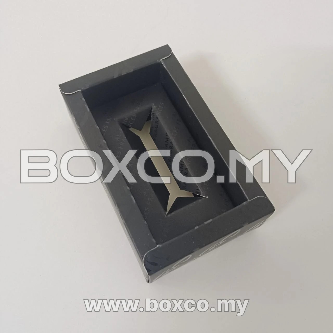 Open black fragrance sample drawer with raised border and Y-shaped insert opening